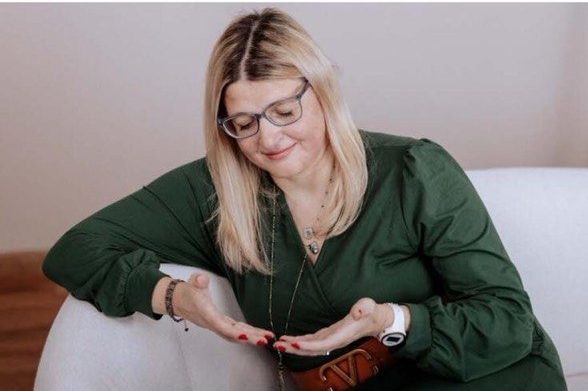 Nadine Stehle sitzt mit geschlossenen Augen und geöffneten Händen bei einer meditativen Übung im Rahmen ihrer Geistigen Lichtchirurgie.